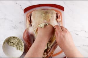 rubbing butter under the skin of turkey