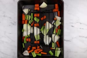 roasting pan with rack and carrots, celery, and onion