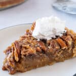 slice of pecan pie on plate with whipped cream