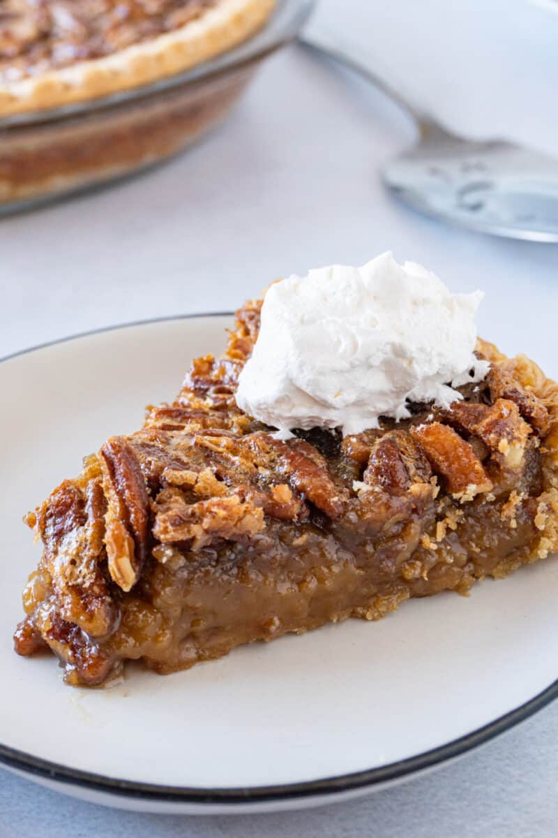 slice of pecan pie on plate with whipped cream