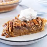 slice of pecan pie on plate with whipped cream featured image