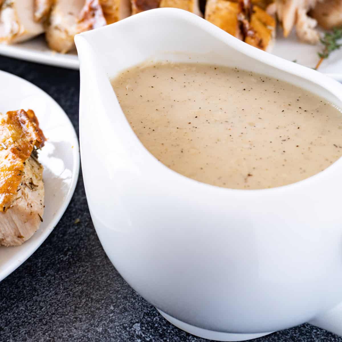 gravy in a gravy boat with turkey in background featured image