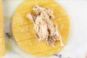 adding turkey filling to corn tortilla