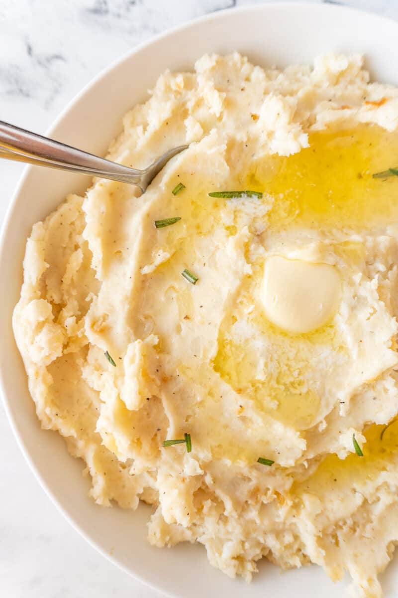 mashed potatoes in bowl with melted butter on top