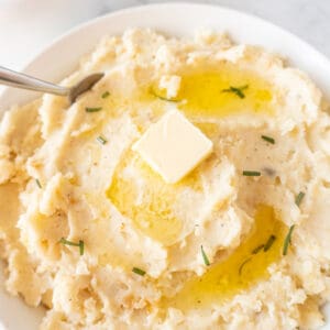 mashed potatoes in bowl with melted butter on top