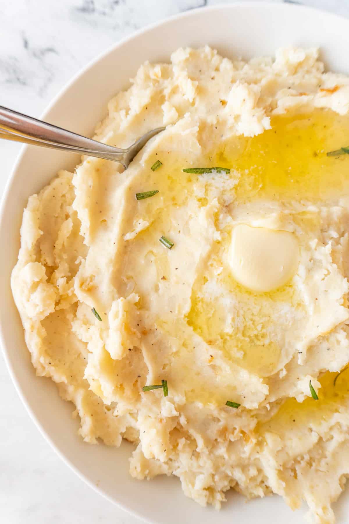 mashed potatoes in bowl with melted butter on top