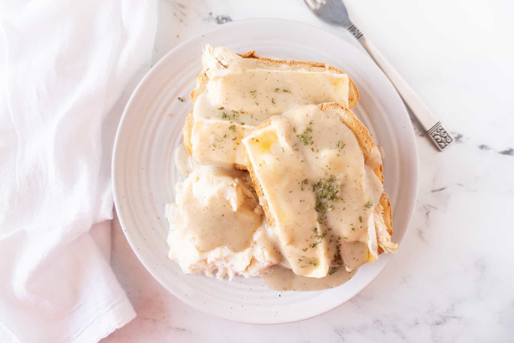 hot turkey sandwich with gravy with fork and napkin