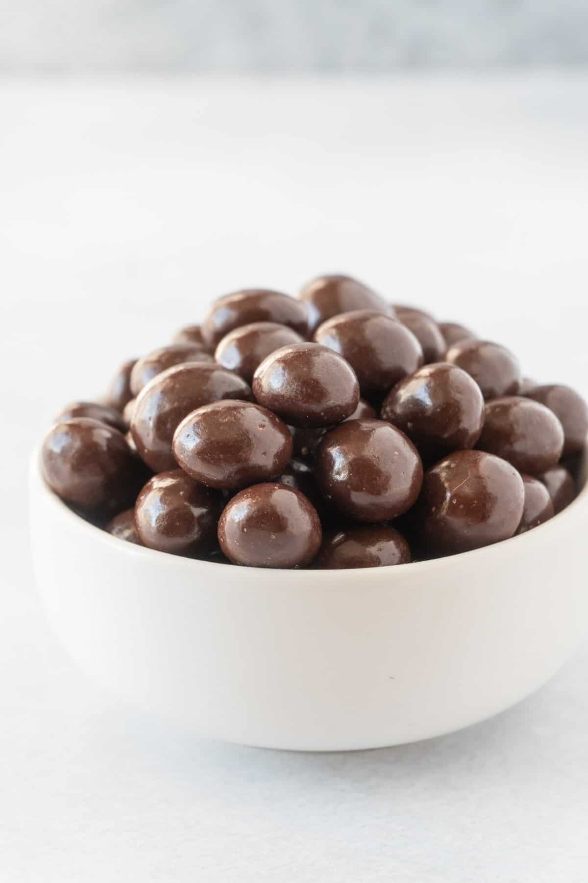 chocolate covered coffee beans in white bowl