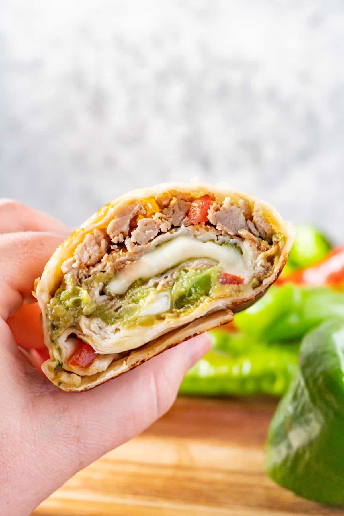 chile relleno burrito cut in half held in hand