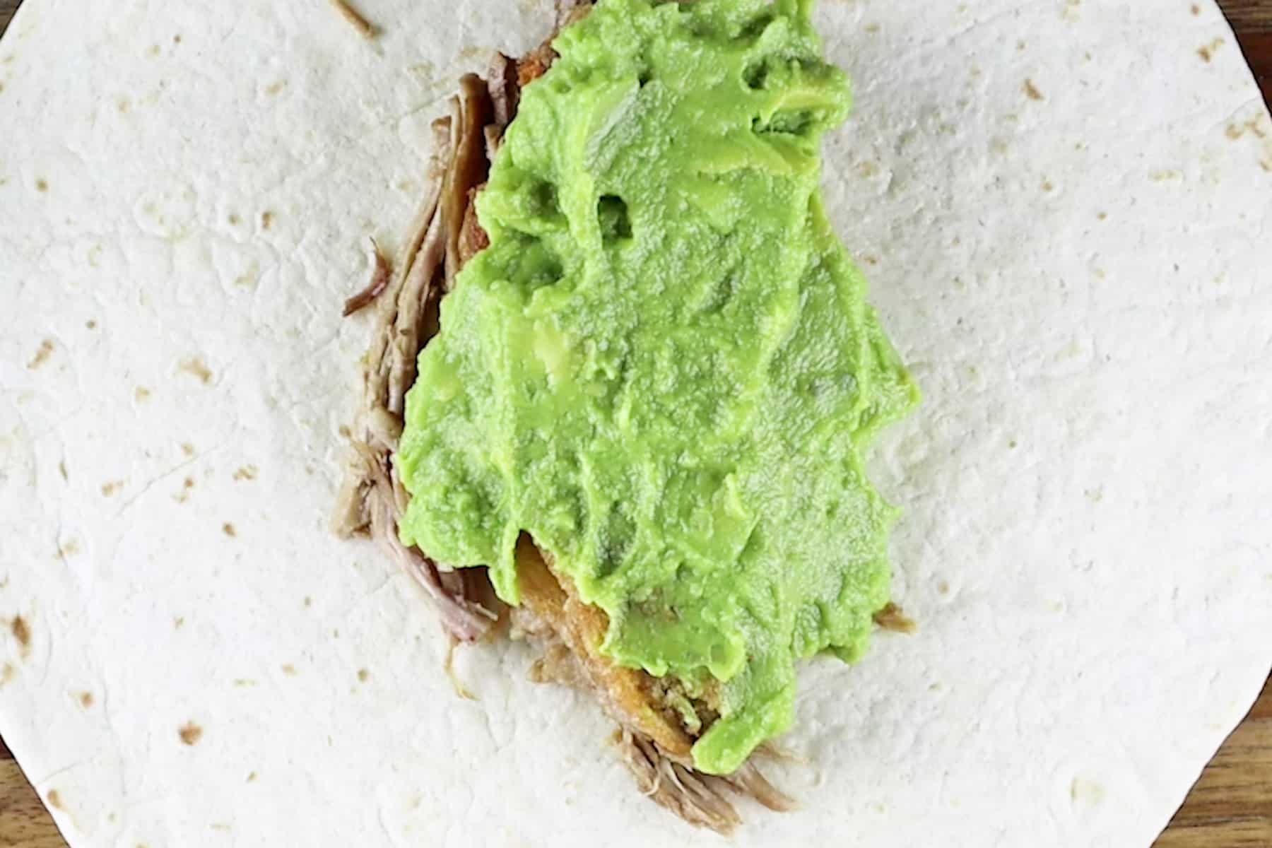 adding guac to burrito