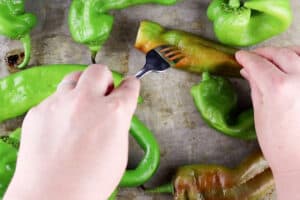 piercing a fresh green chile with a fork