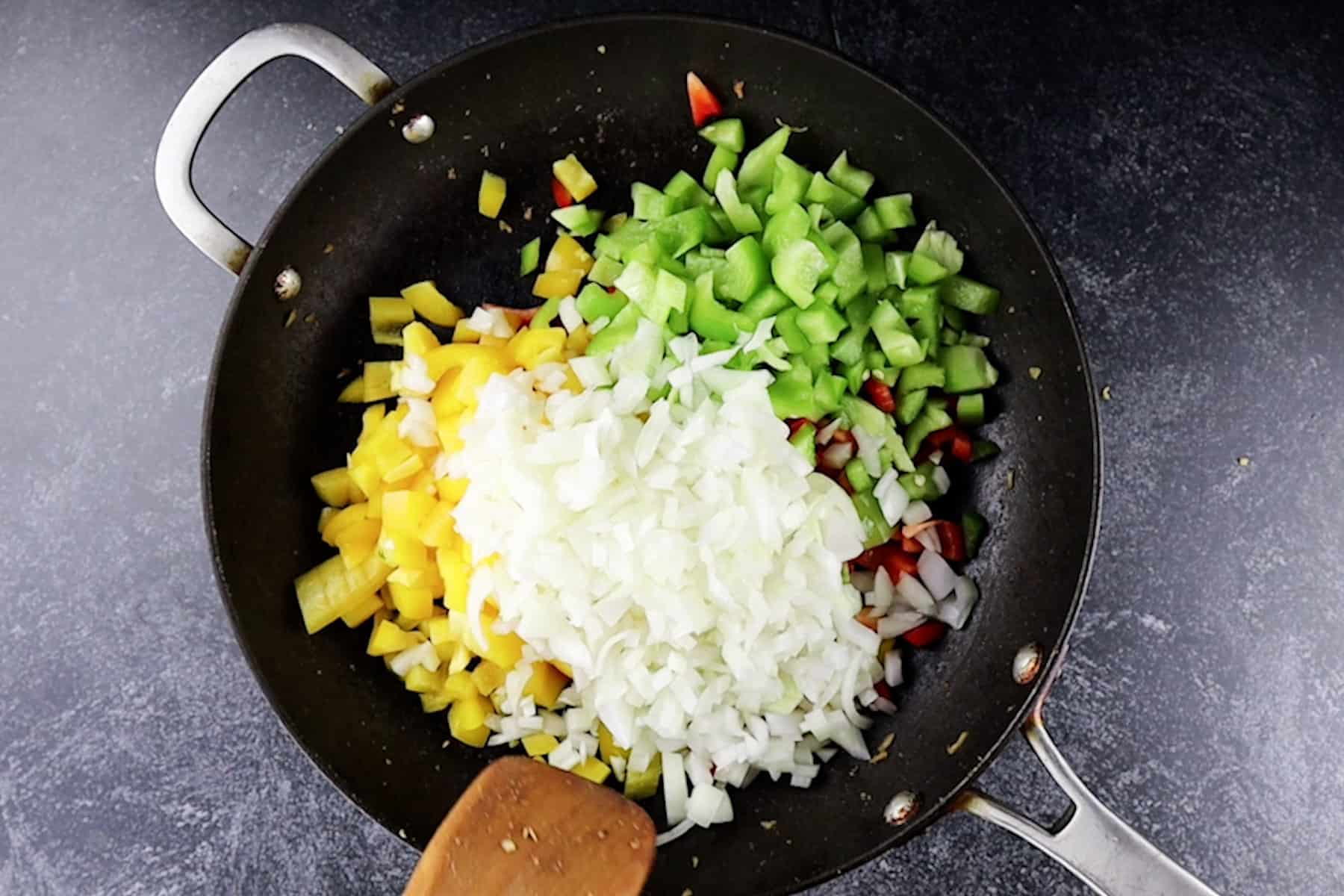 adding bell pepper and onion to pan