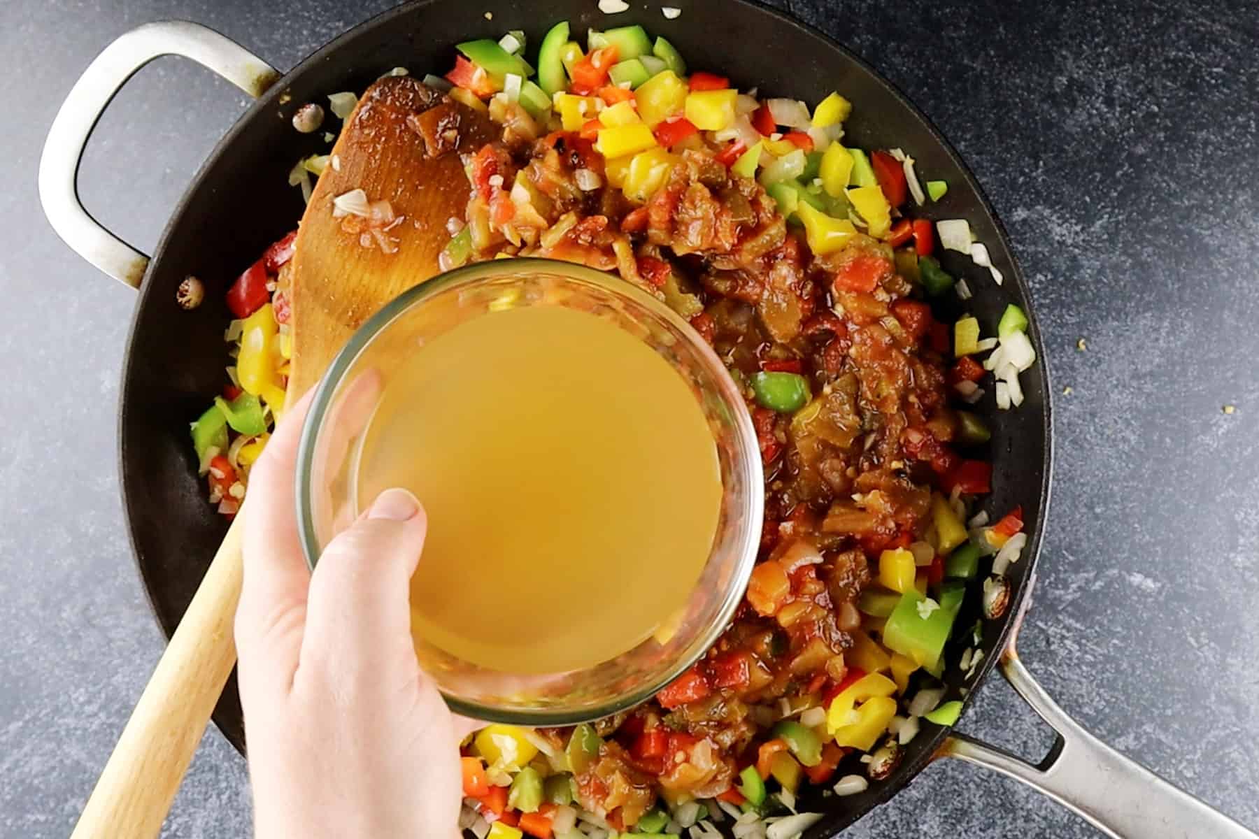 adding broth to skillet