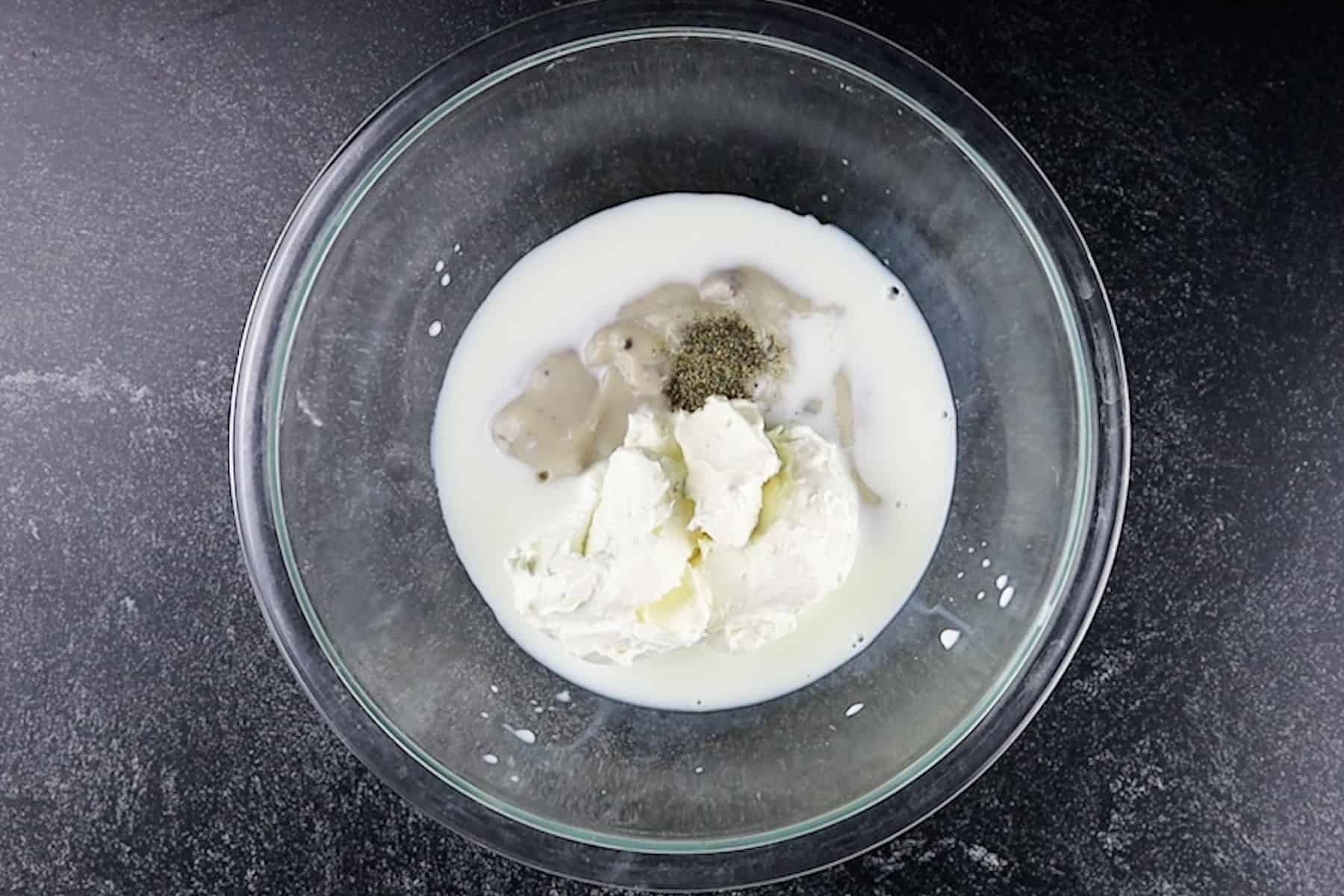 milk, cream cheese, cream of mushroom soup and pepper in bowl before mixing