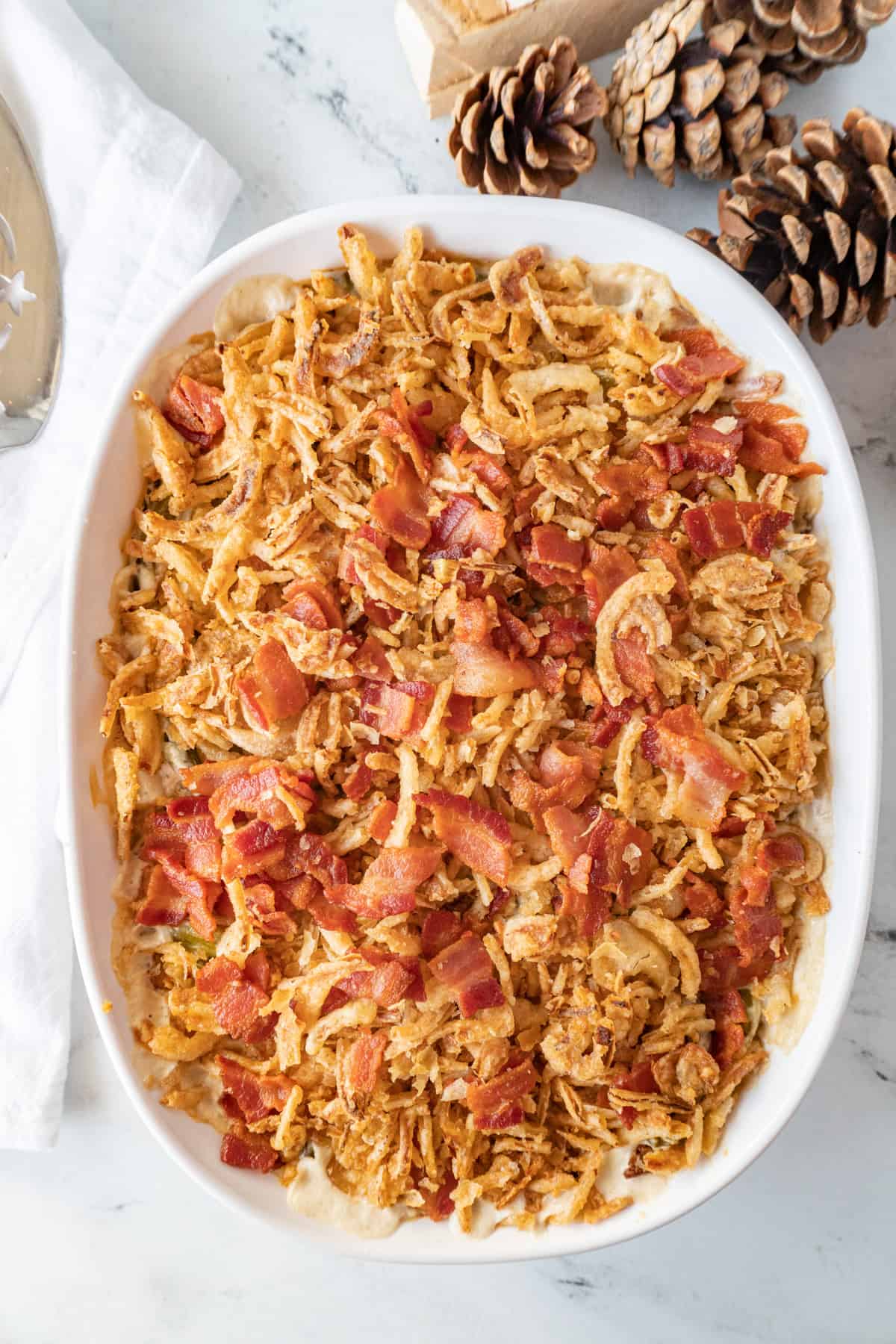 green bean casserole with cream cheese in baking dish flat lay