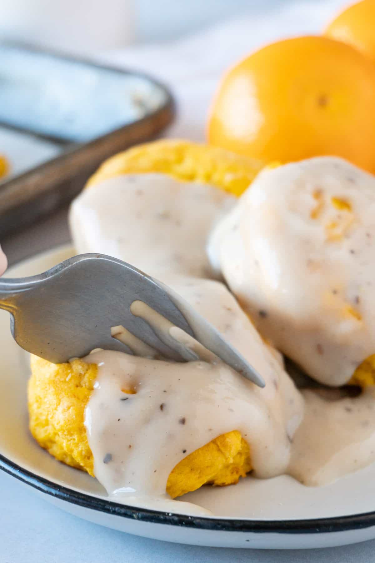 fork cutting into gravy on biscuits