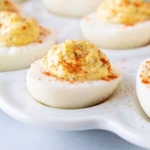 smoked deviled egg with paprika on white platter featured image.