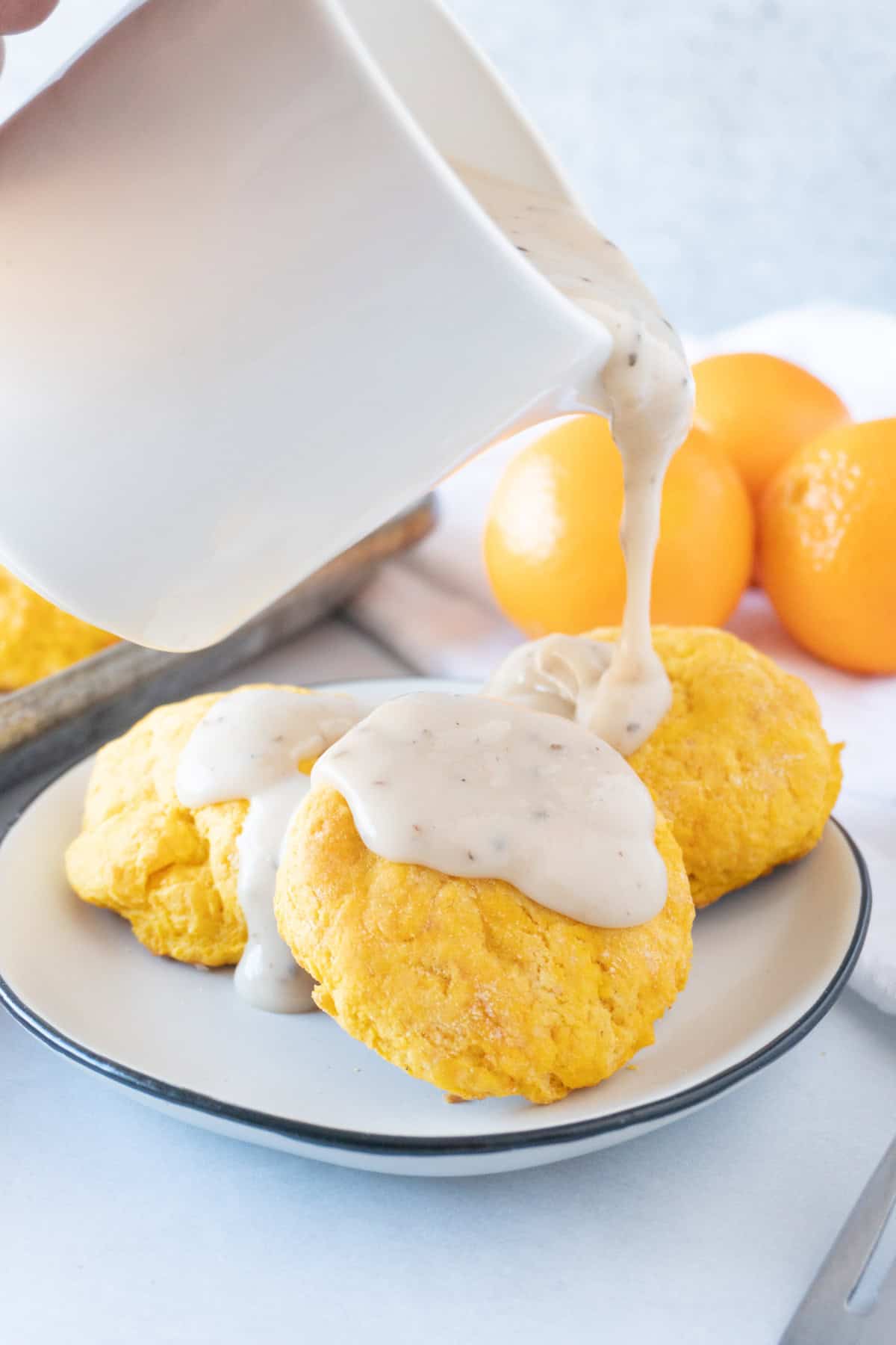 gravy being poured onto sweet potato biscuits.