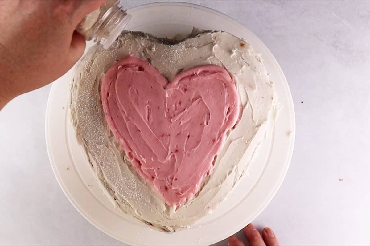 adding sanding sugar to white part on top of cake