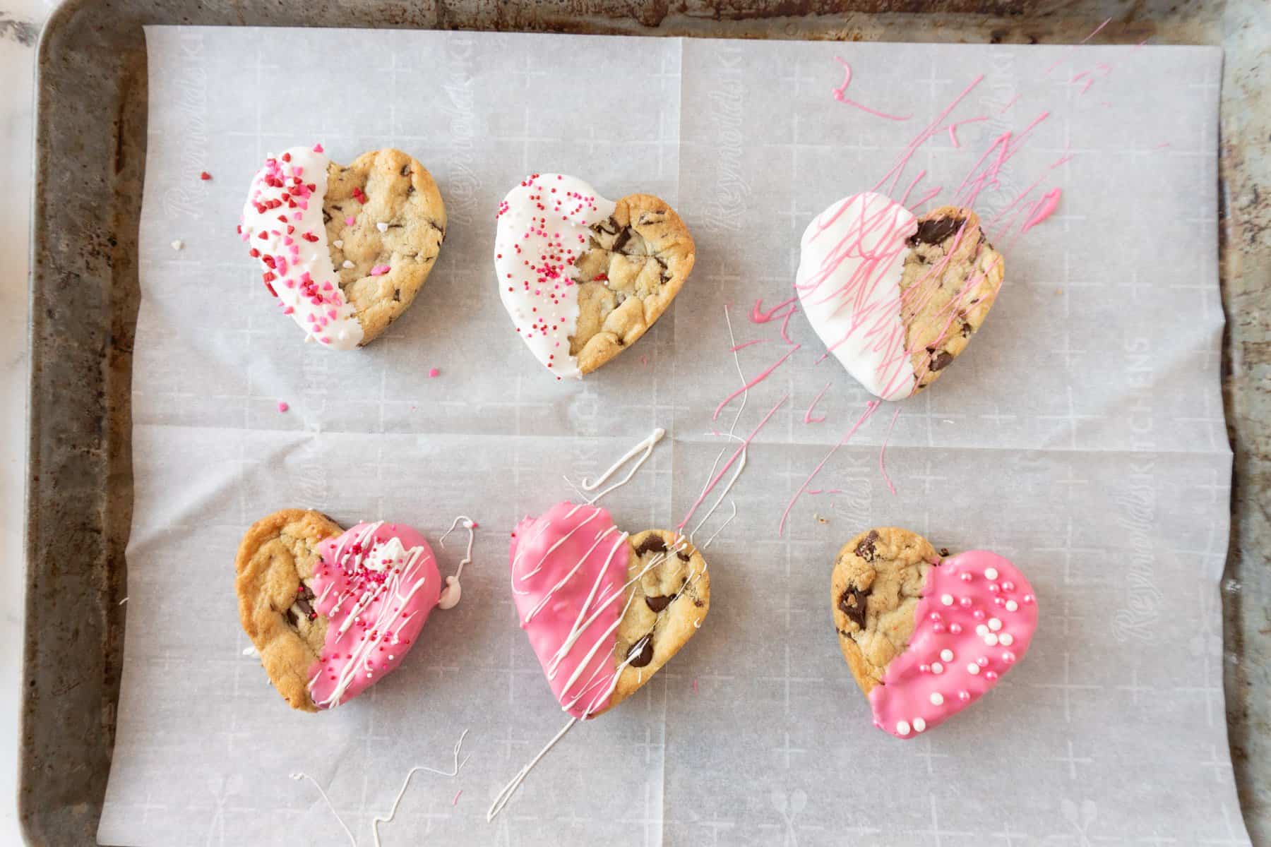 heart shaped chocolate chip cookies decorated on baking sheet.