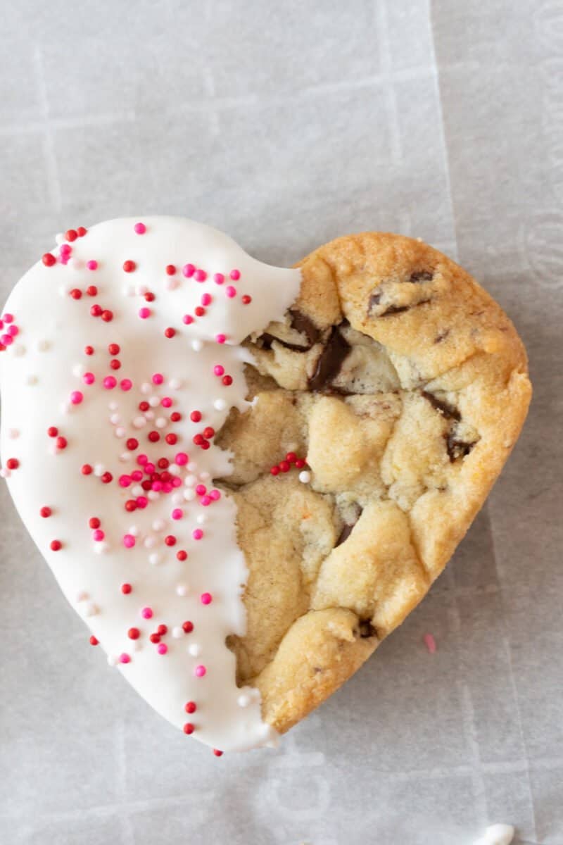heart shaped chocolate chip cookie half white with pink sprinkles