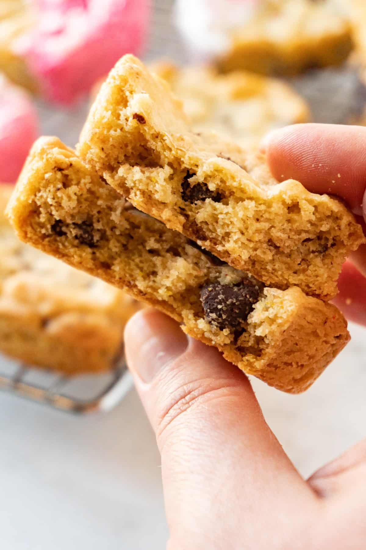 heart shaped chocolate chip cookie in half in hand