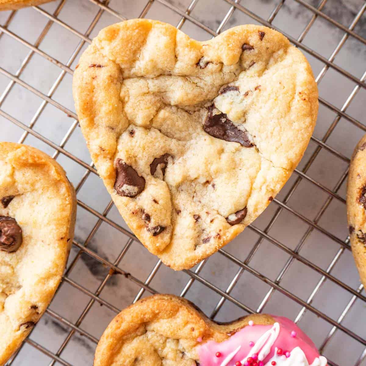 heart shaped chocolate chip cookie on bcooling rack featured image