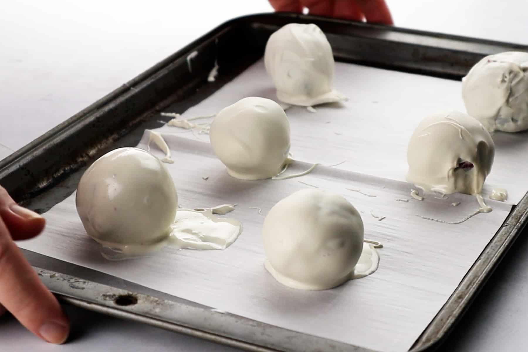 dipped cake balls on parchment lined baking sheet