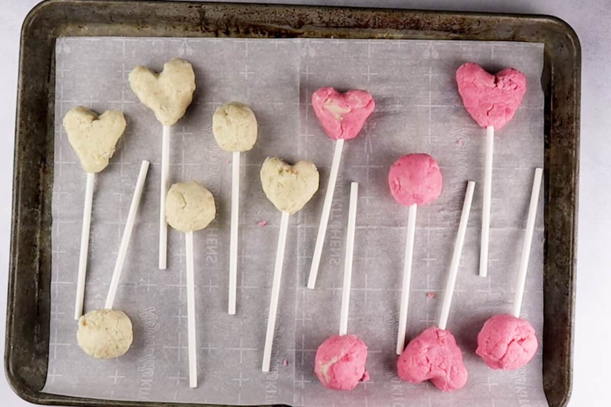 cake pops with sticks on baking sheet before dipping