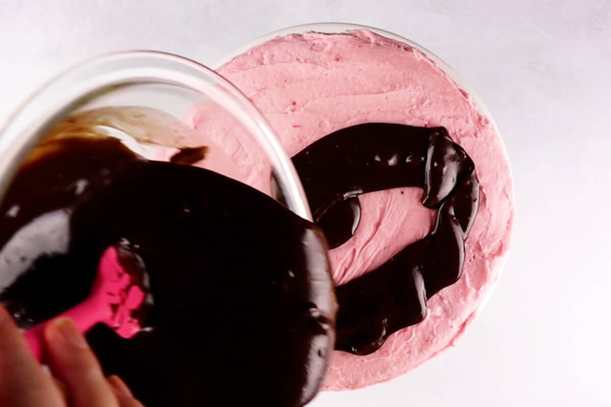 pouring ganache over cake