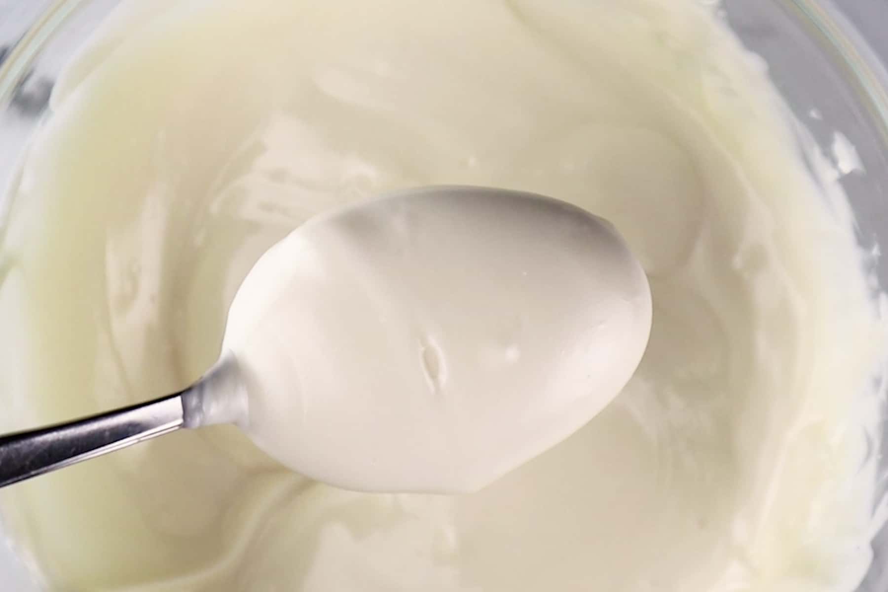 white candy melts on spoon after melting in bowl.