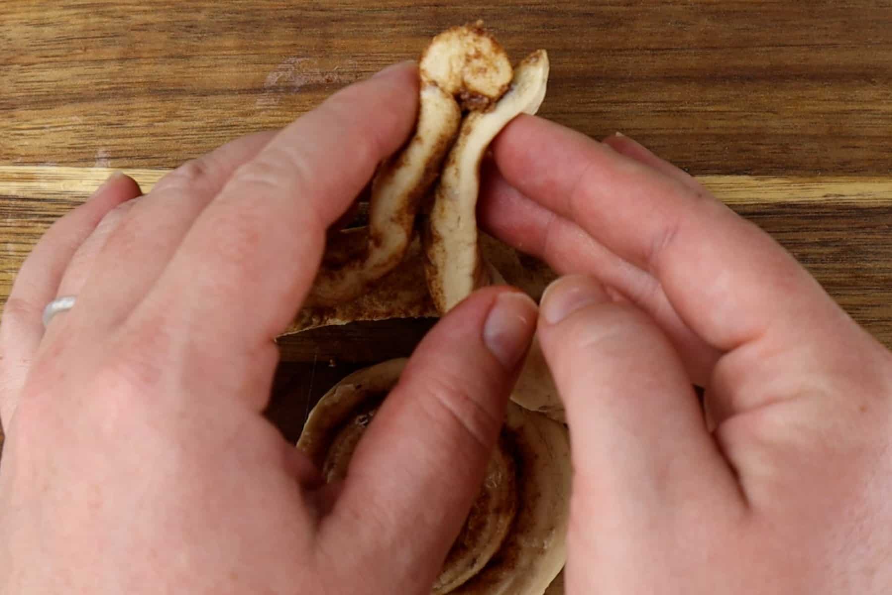 pressing ends of urolled dough together