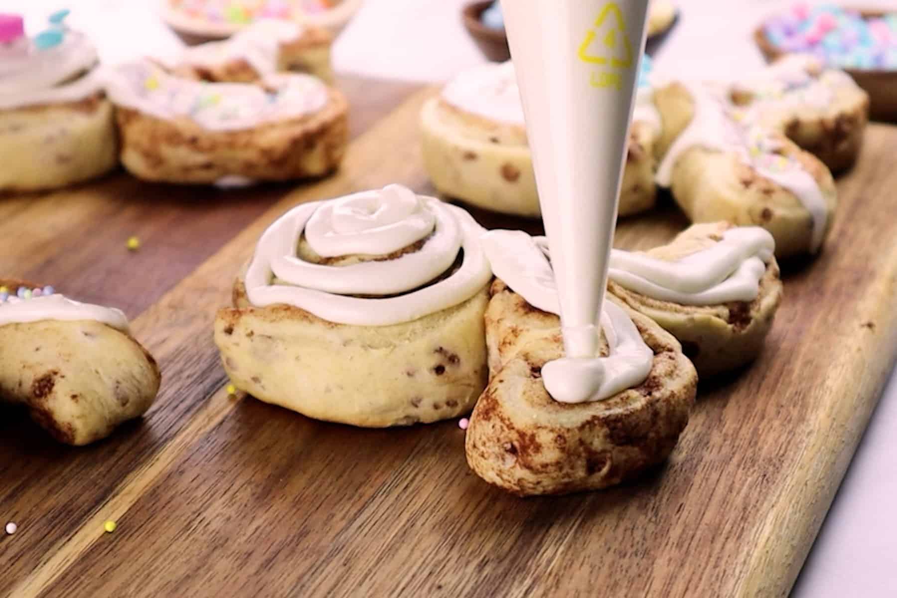 adding frosting to bunny cinnamon rolls ears