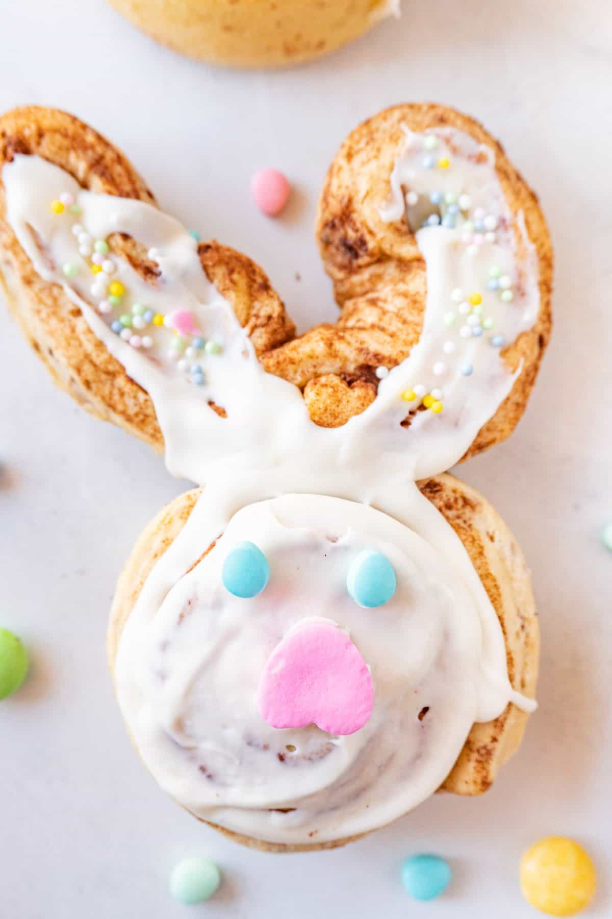 bunny cinnamon roll decorated with Easter candy on a white background.