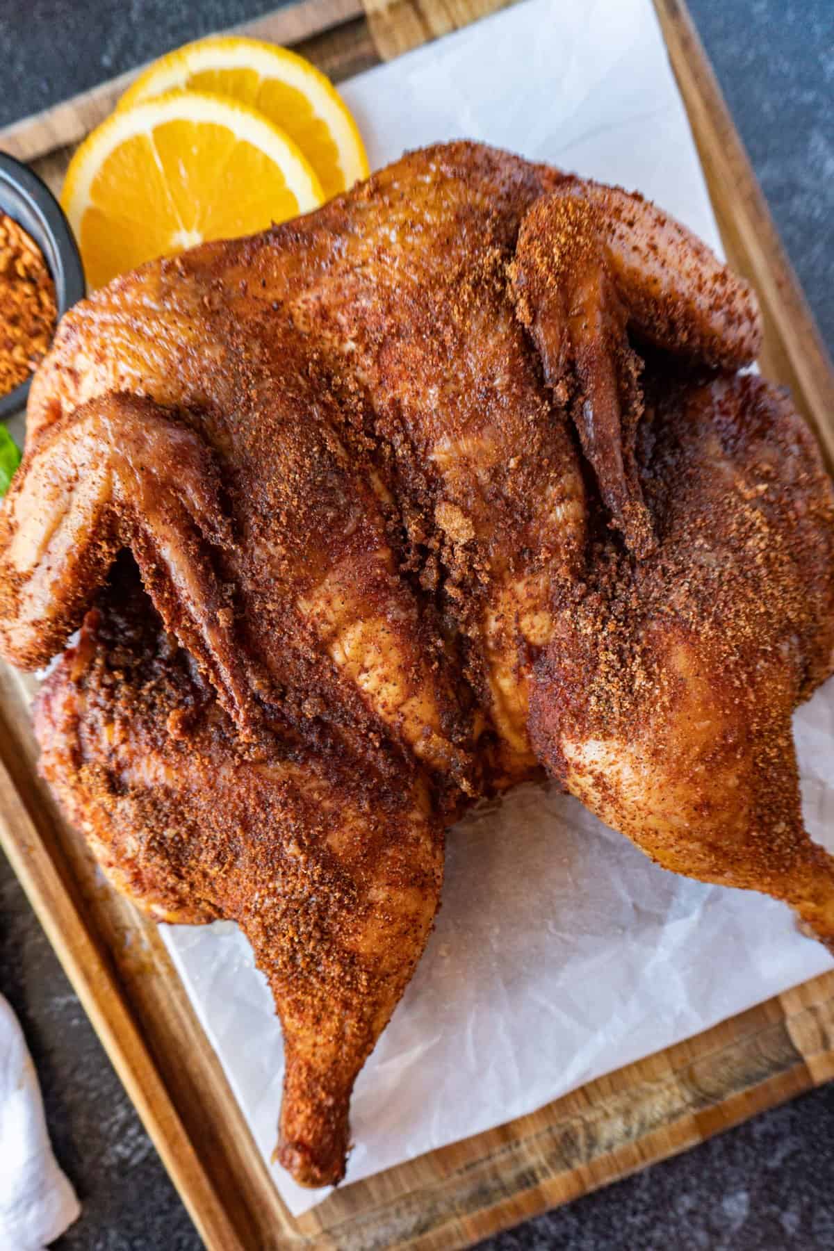 smoked spatchcock chicken flatlay on parchment lined cutting boards