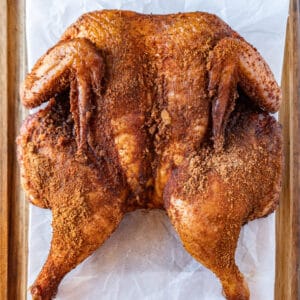 smoked spatchcock chicken on parchment paper featured image