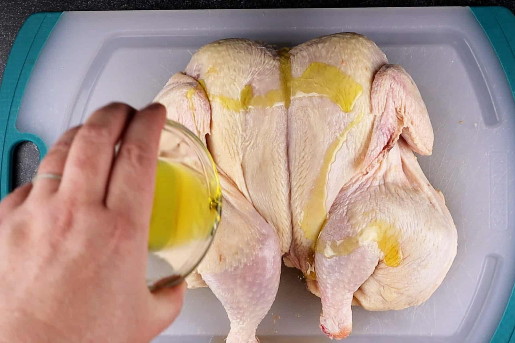 adding olive oil to chicken