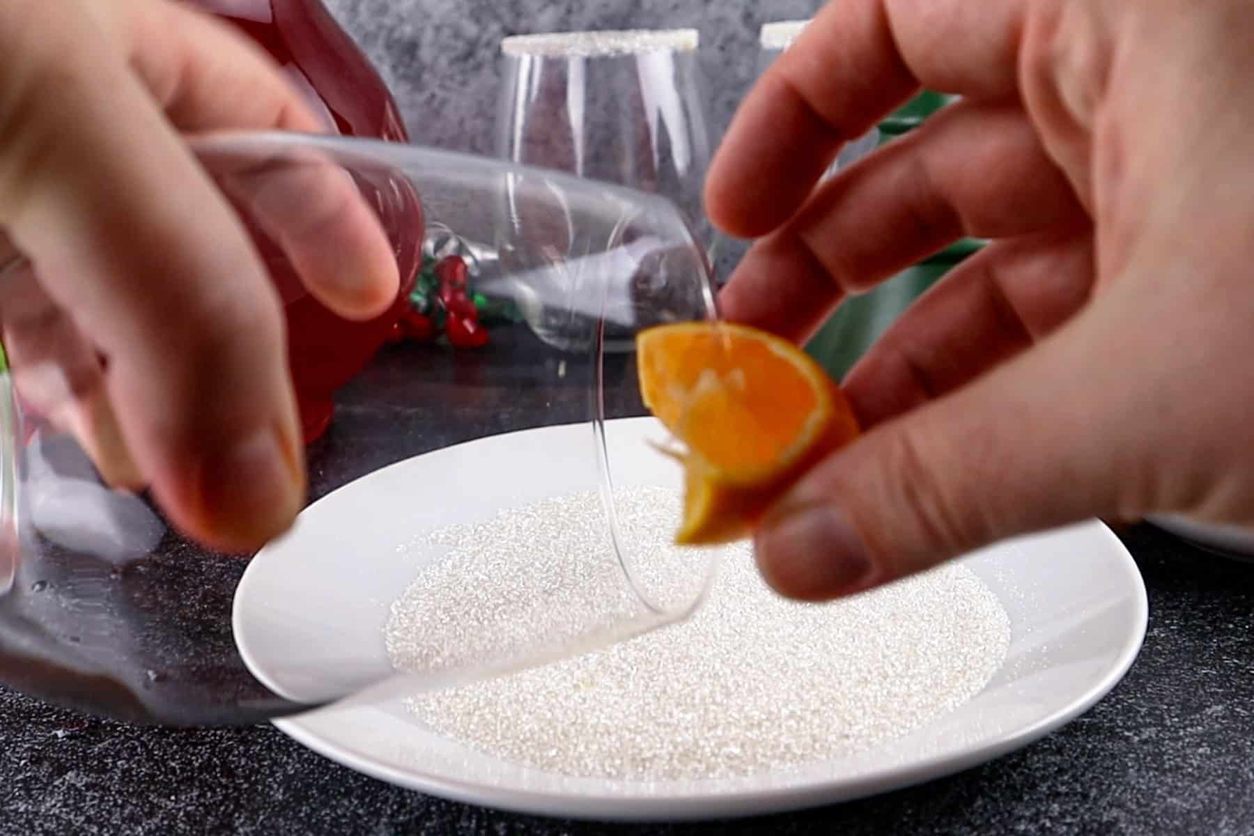 wiping glass rim with orange slice
