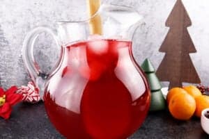 stirring cranberry mint julep in pitcher