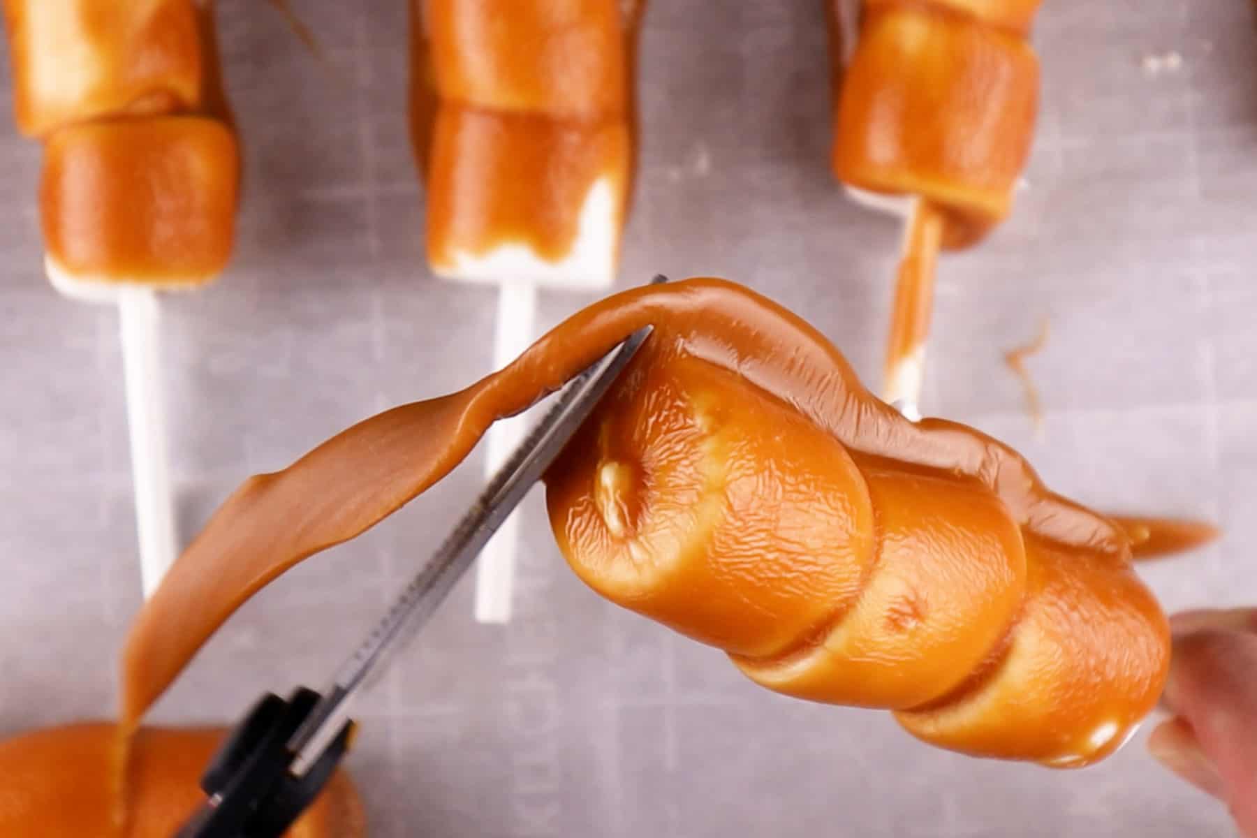 Trimming excess caramel off of marshmallow