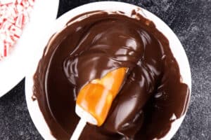 dipping caramel covered marshmallows in chocolate