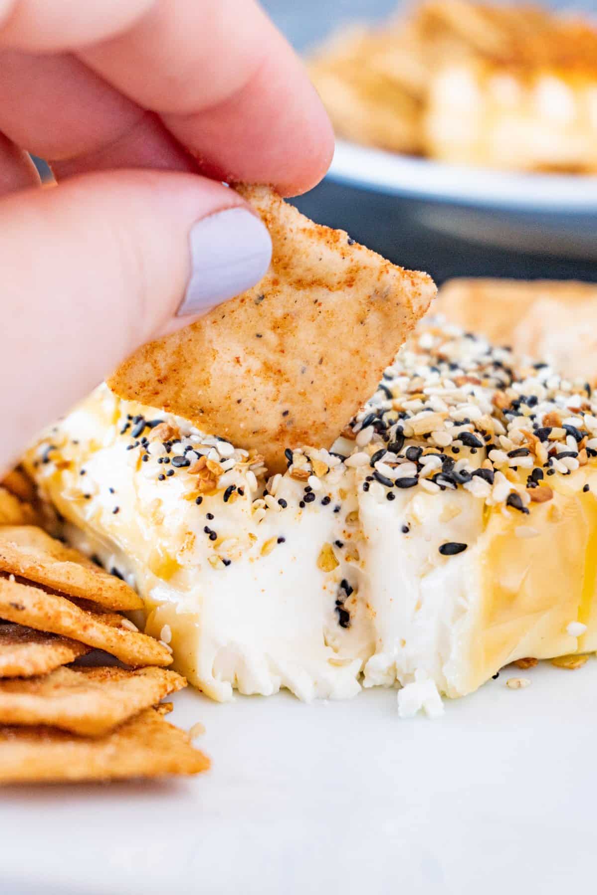 using a cracker to scoop some cream cheese