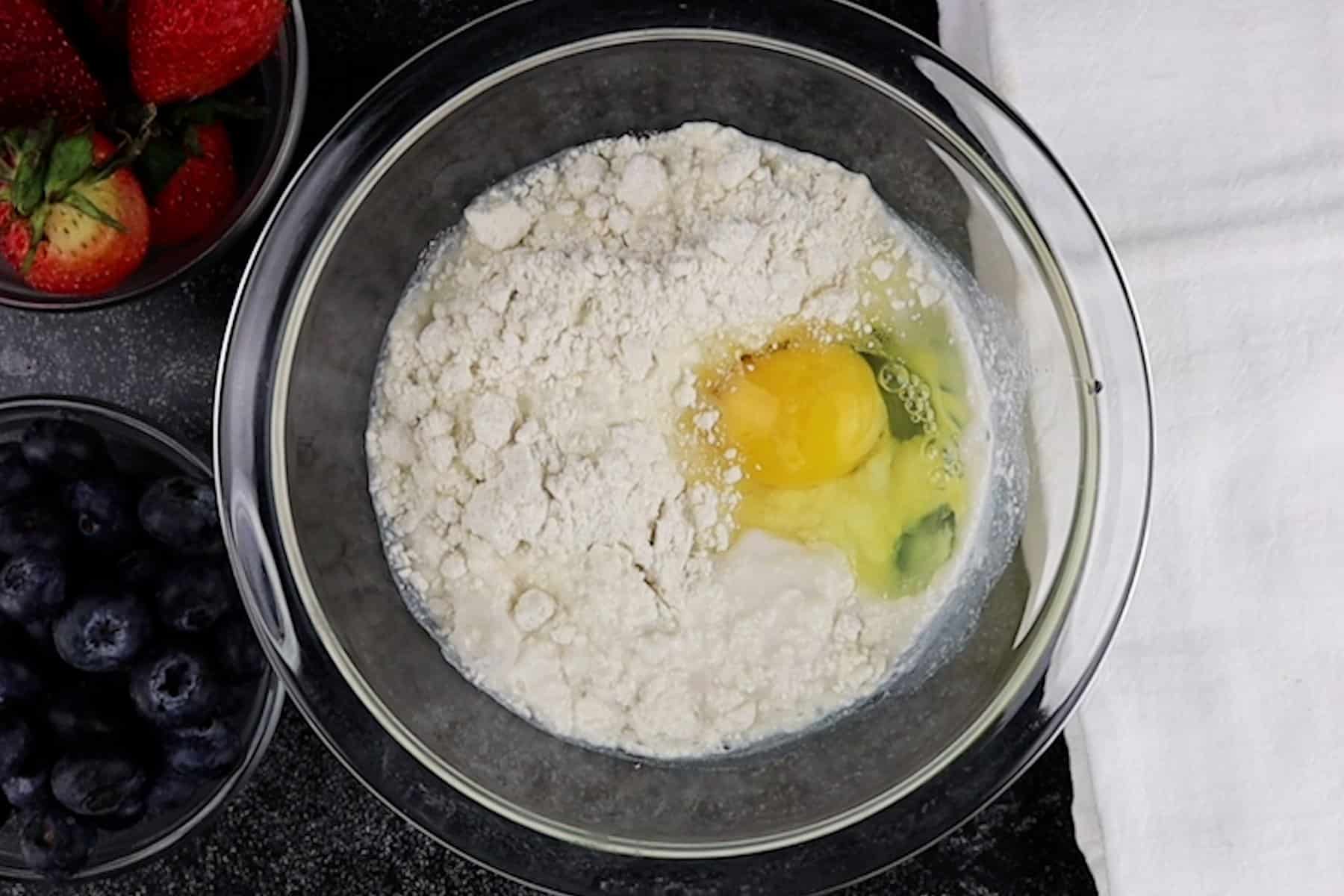 adding pancake batter ingredients to mixing bowl.