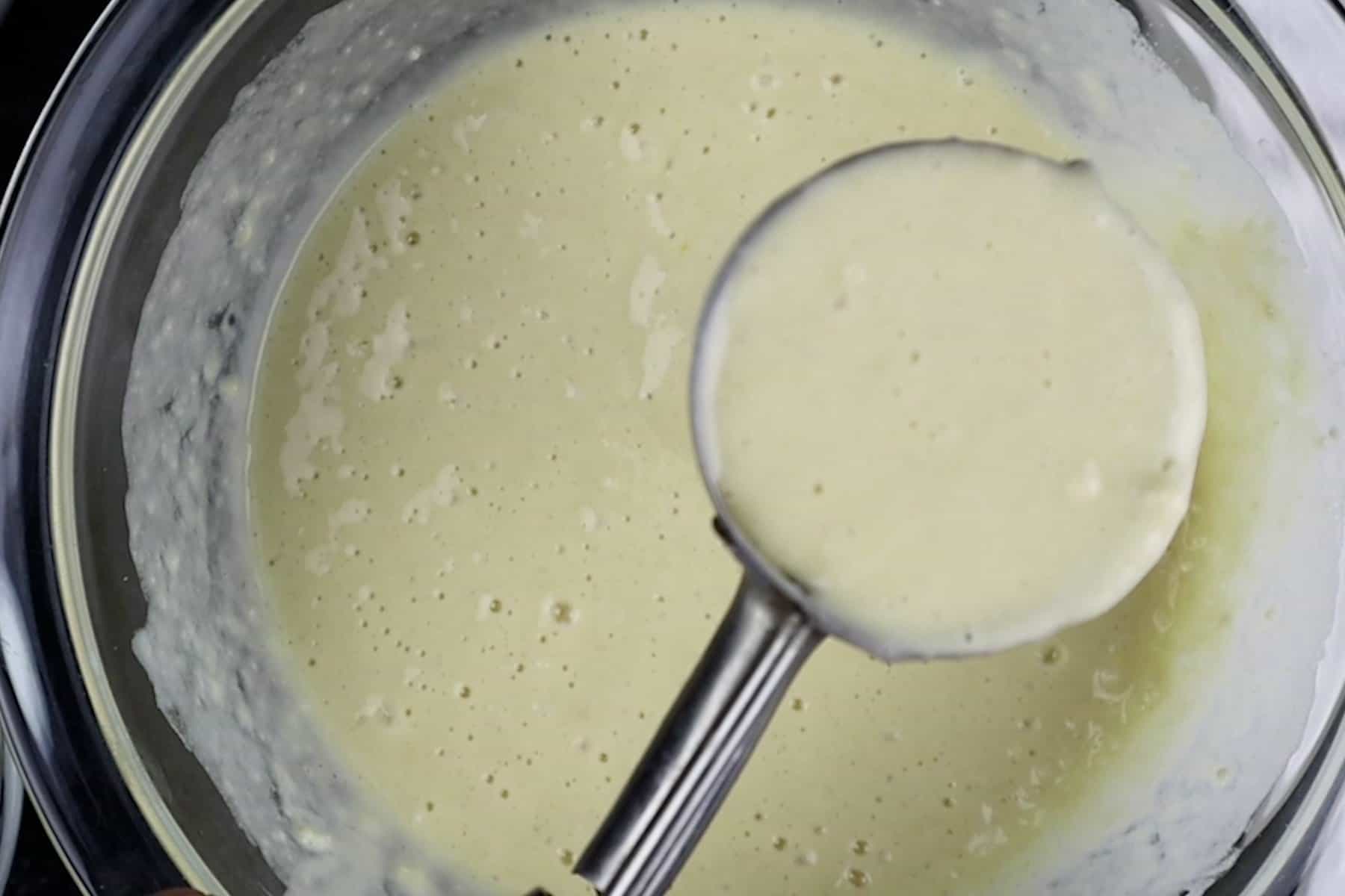scooping pancake batter out of bowl.