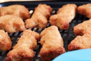 cooked dino nuggerts coming out of air fryer.
