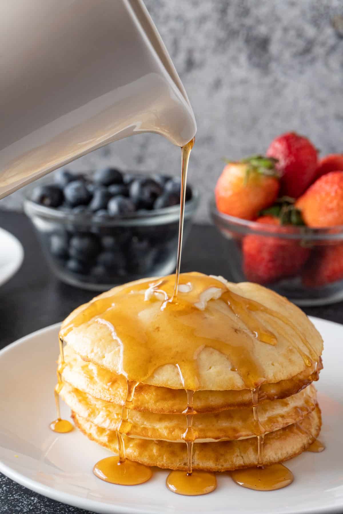 pouring syrup over pancakes.