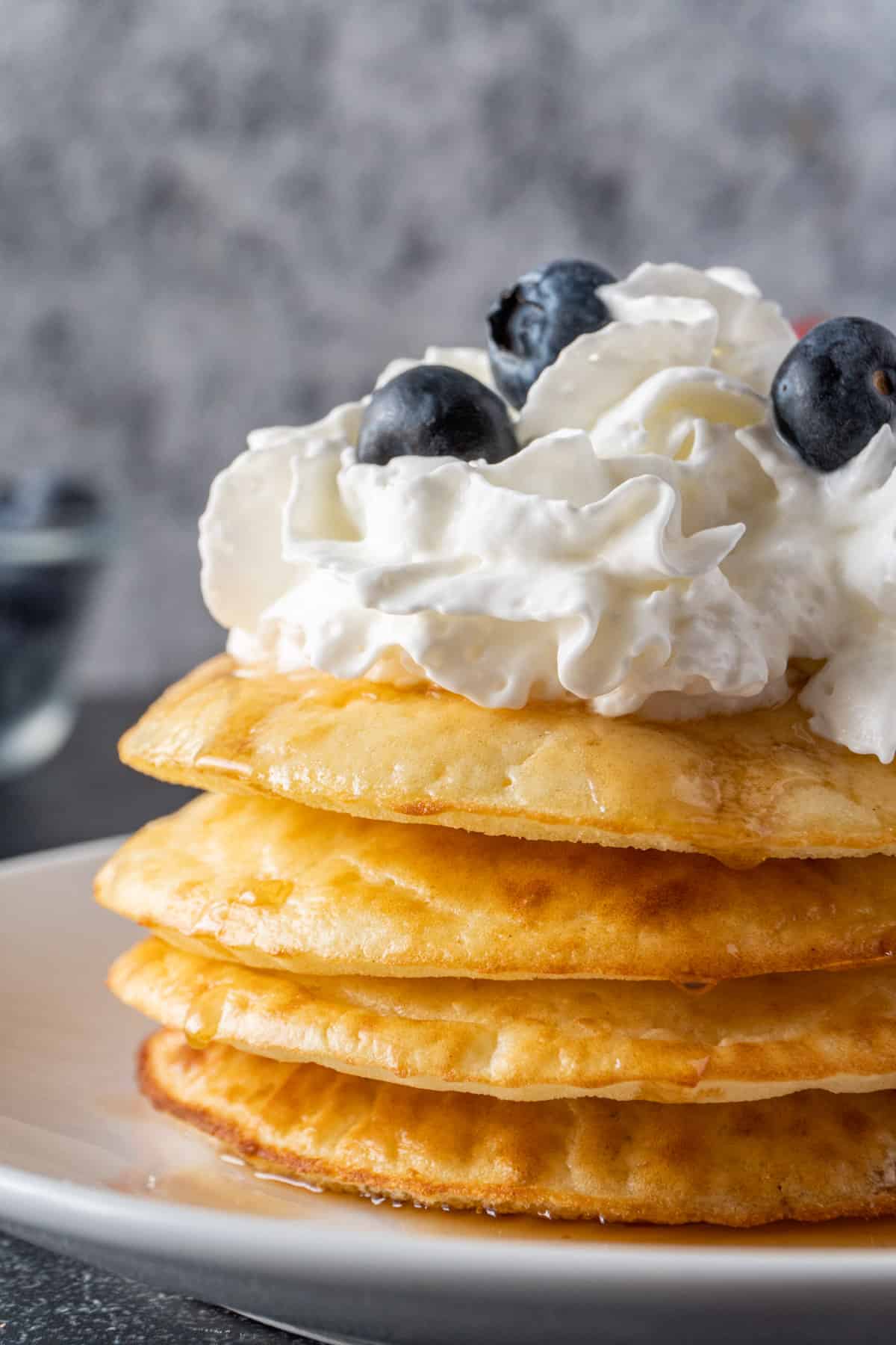 air fryer pancakes with wihhped cream an blueberries close up.