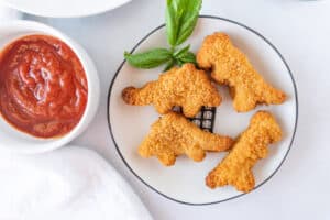 dino nuggets on plate near ketchup.