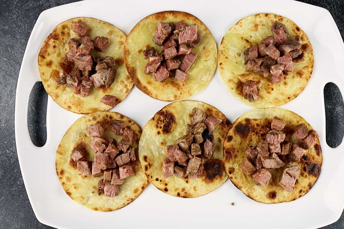 Fried corn tortillas with cubed tri-tip  on each one.