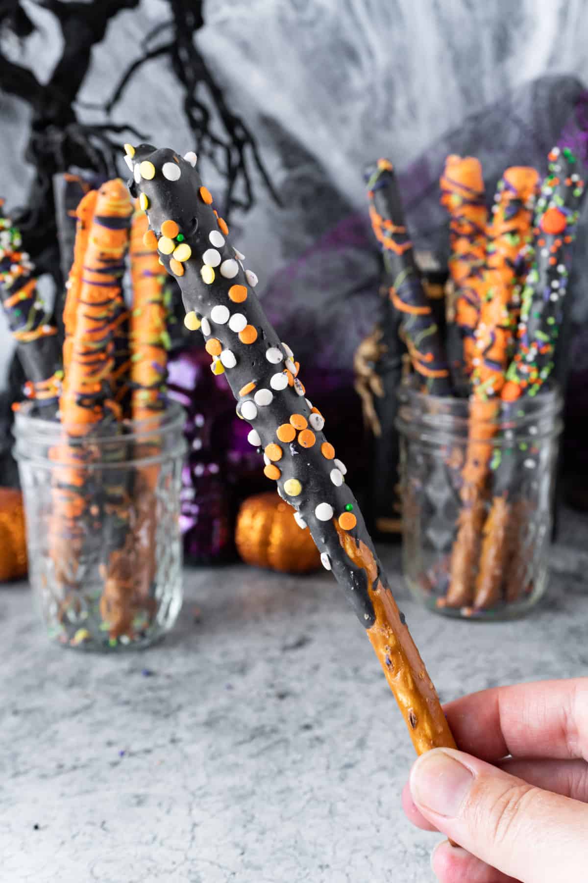 holding a decorated pretzel rod